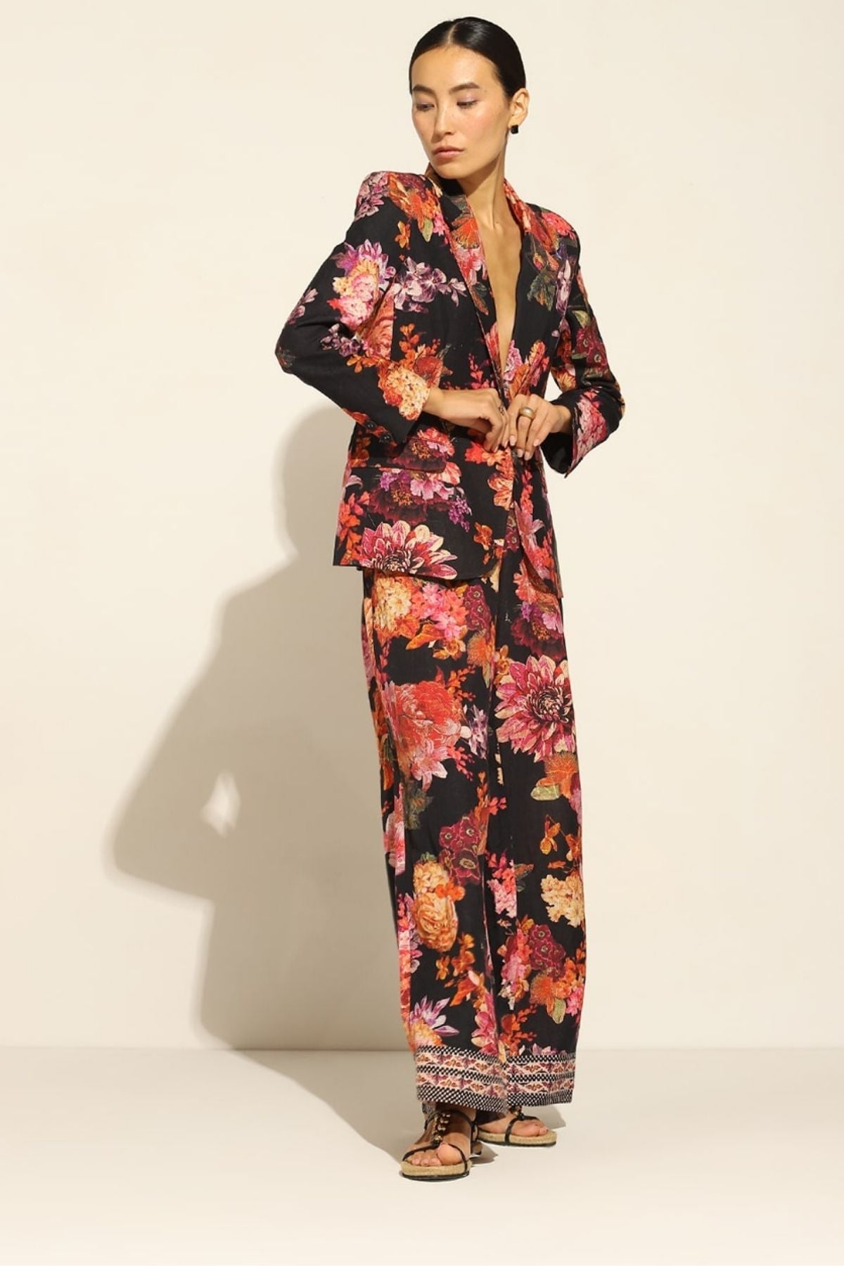 A person wearing a satin blend jacket with a floral pattern, in multicolor, featuring a notched lapel collar and straight sleeves.