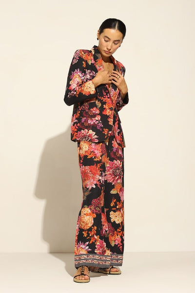 A person wearing a satin blend jacket with a floral pattern, in multicolor, featuring a notched lapel collar and straight sleeves.