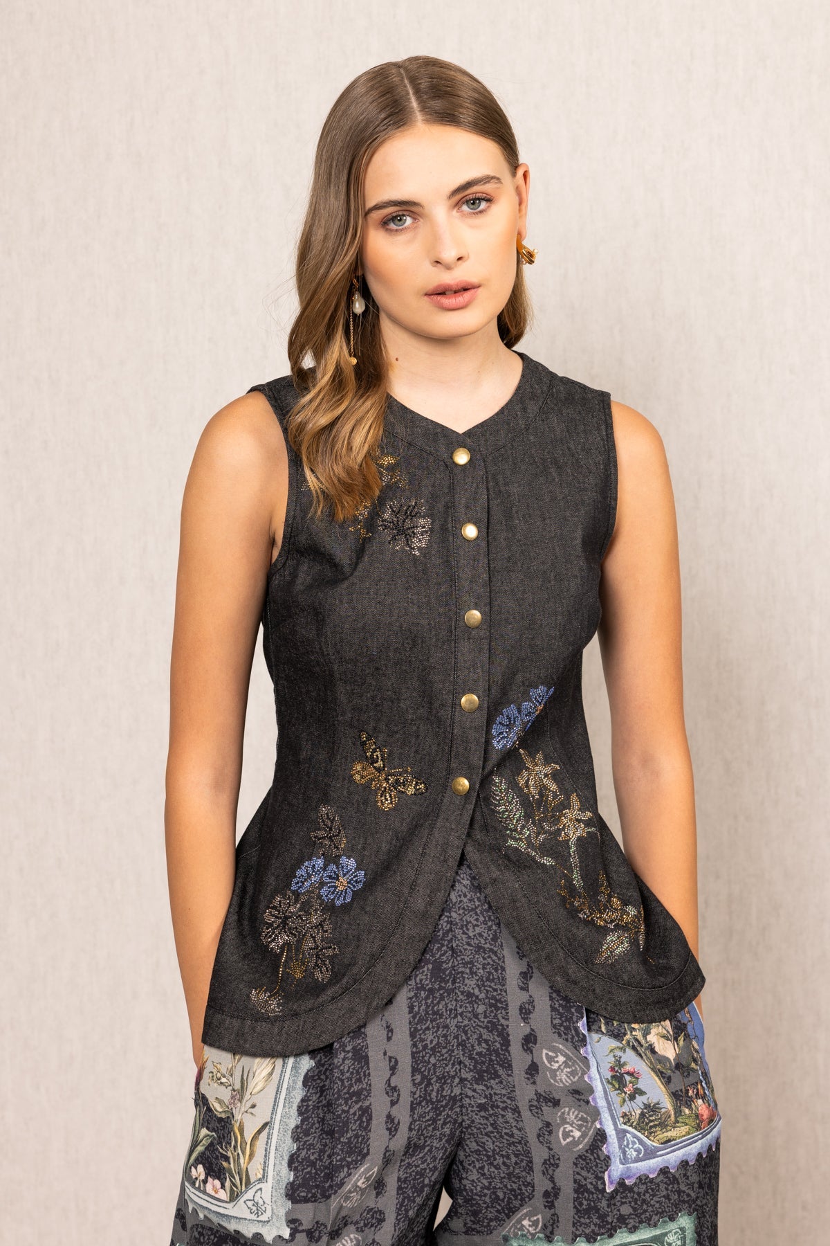Ranna Gill Aster Sleeveless Waist Coat A dark sleeveless top with floral embroidery