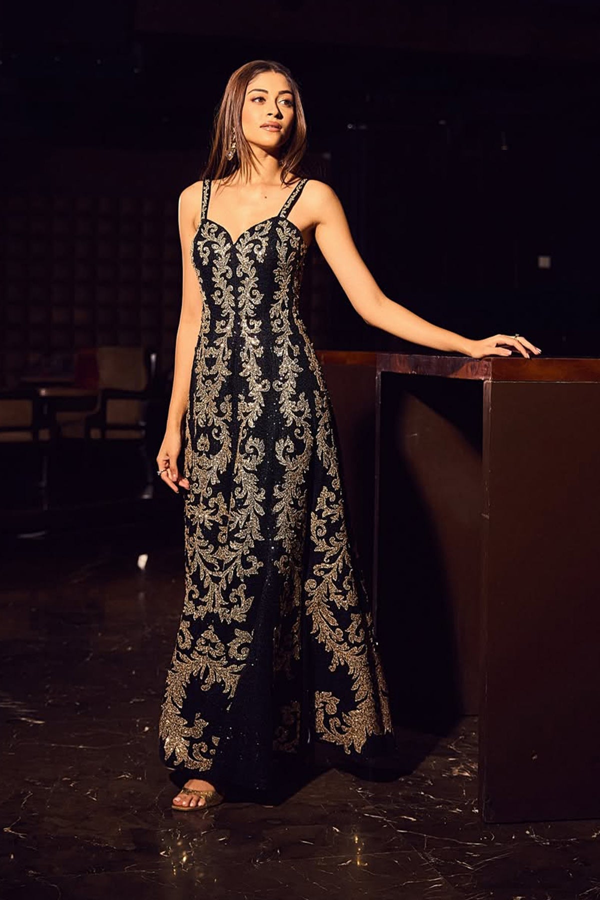 Nandini Gupta wearing the Eva Gown by Ranna Gill, a black designer evening gown with intricate gold embroidery and elegant strappy detailing