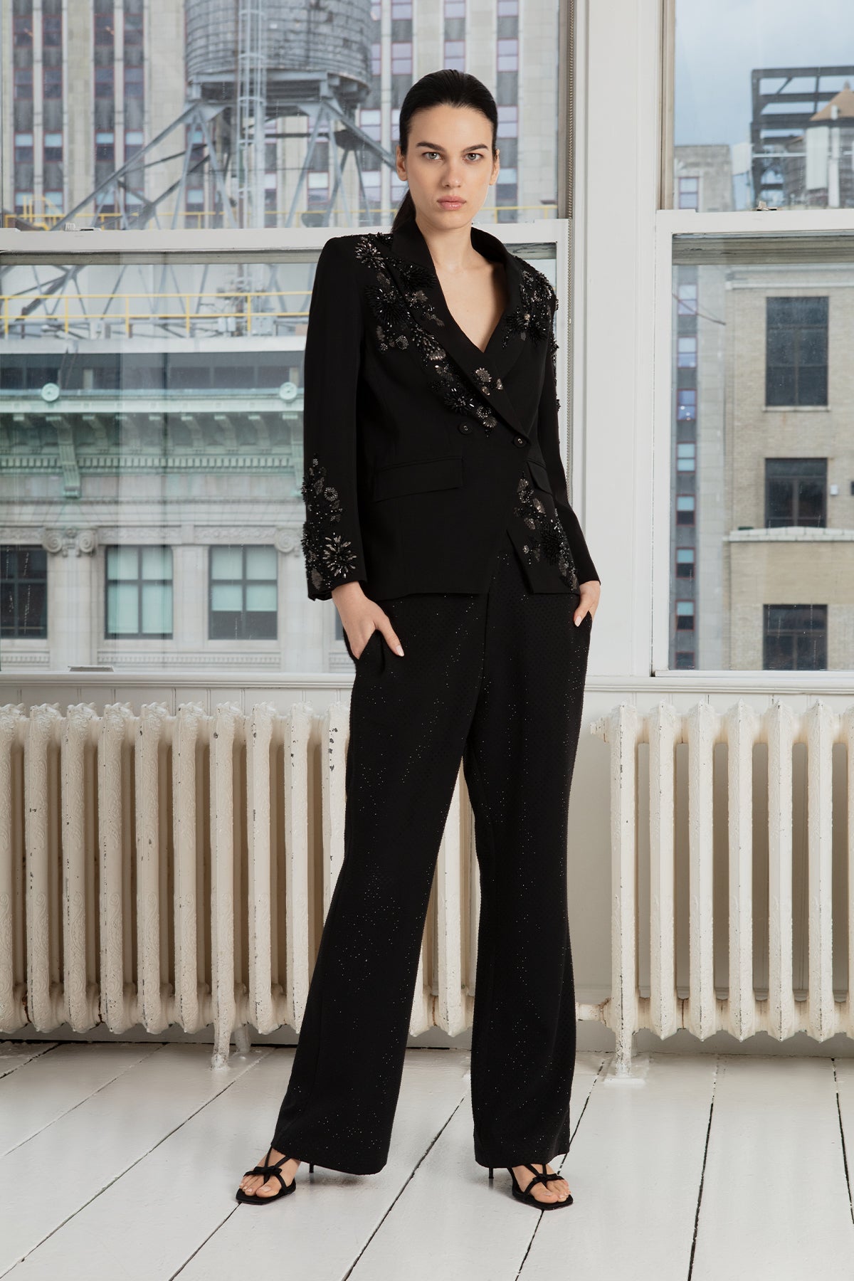 a black crepe blend jacket with long sleeves and a notched lapel collar, paired with trousers.