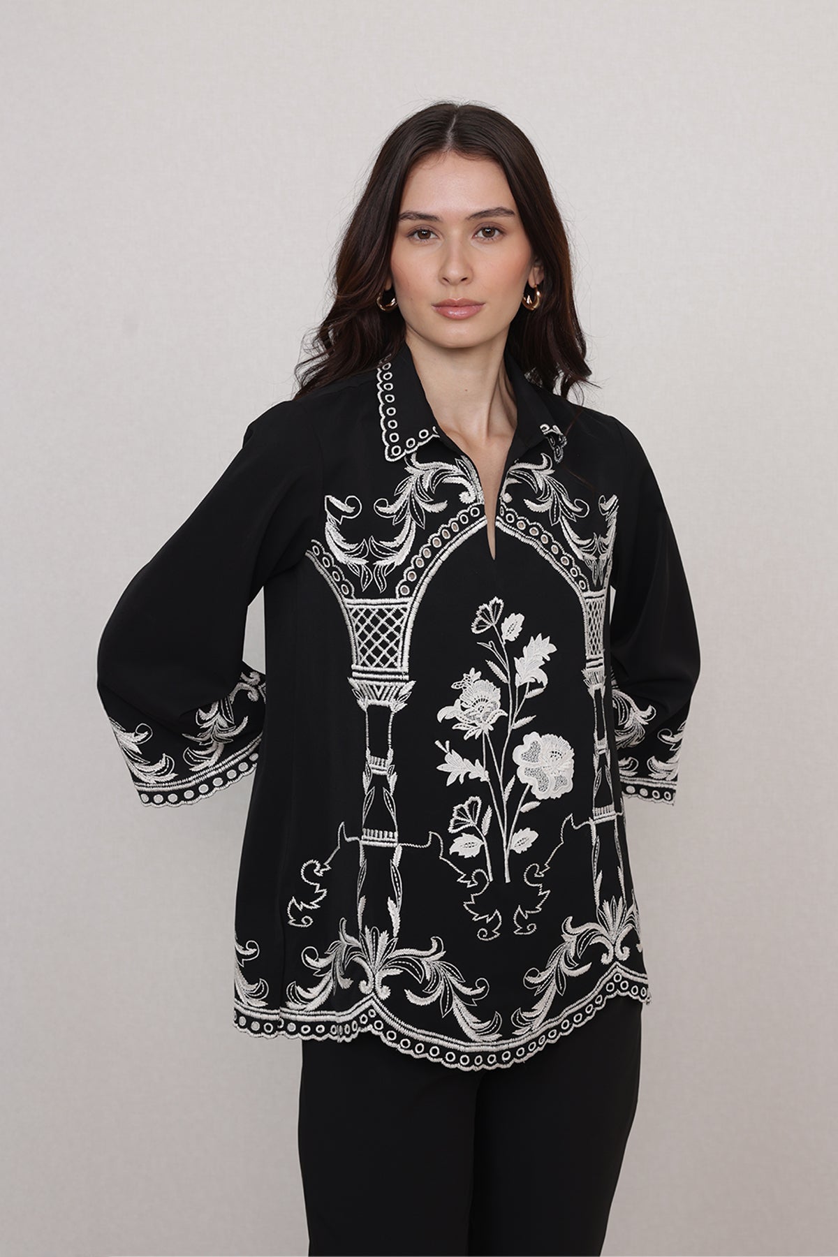 Ranna Gill Casa Blouse wearing a black blouse with white floral and geometric patterns.