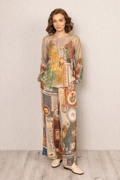 Woman wearing a colorful patterned outfit against a plain background