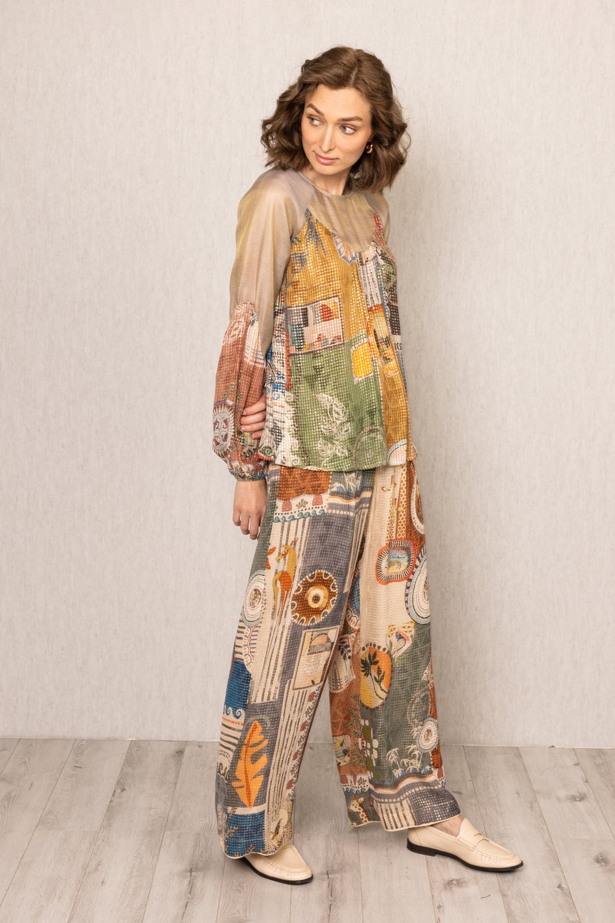 Woman wearing a patchwork outfit with a plain background