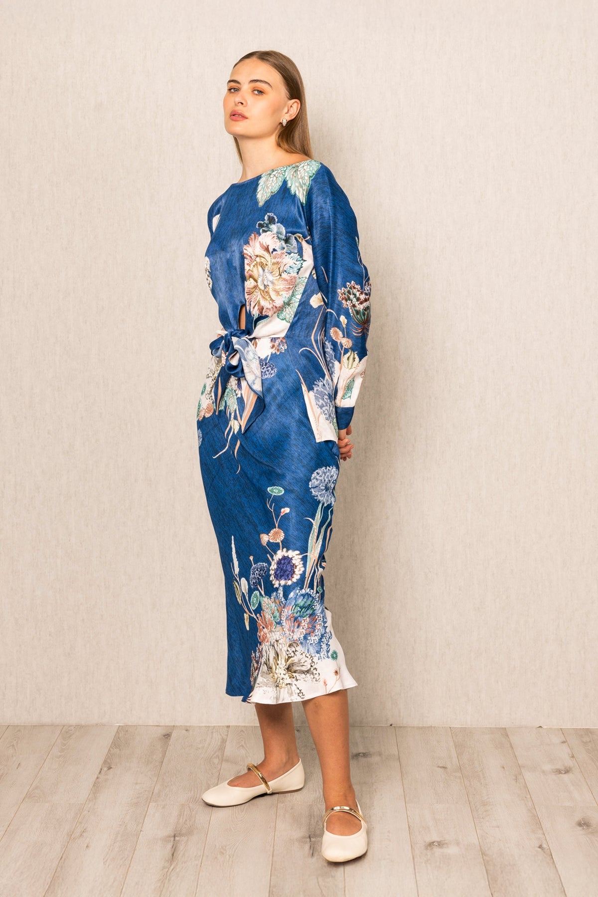 Valencia Front Tie Blouse and Skirt set, blue floral print midi dress with long sleeves, tie detail at waist, and white hem accent