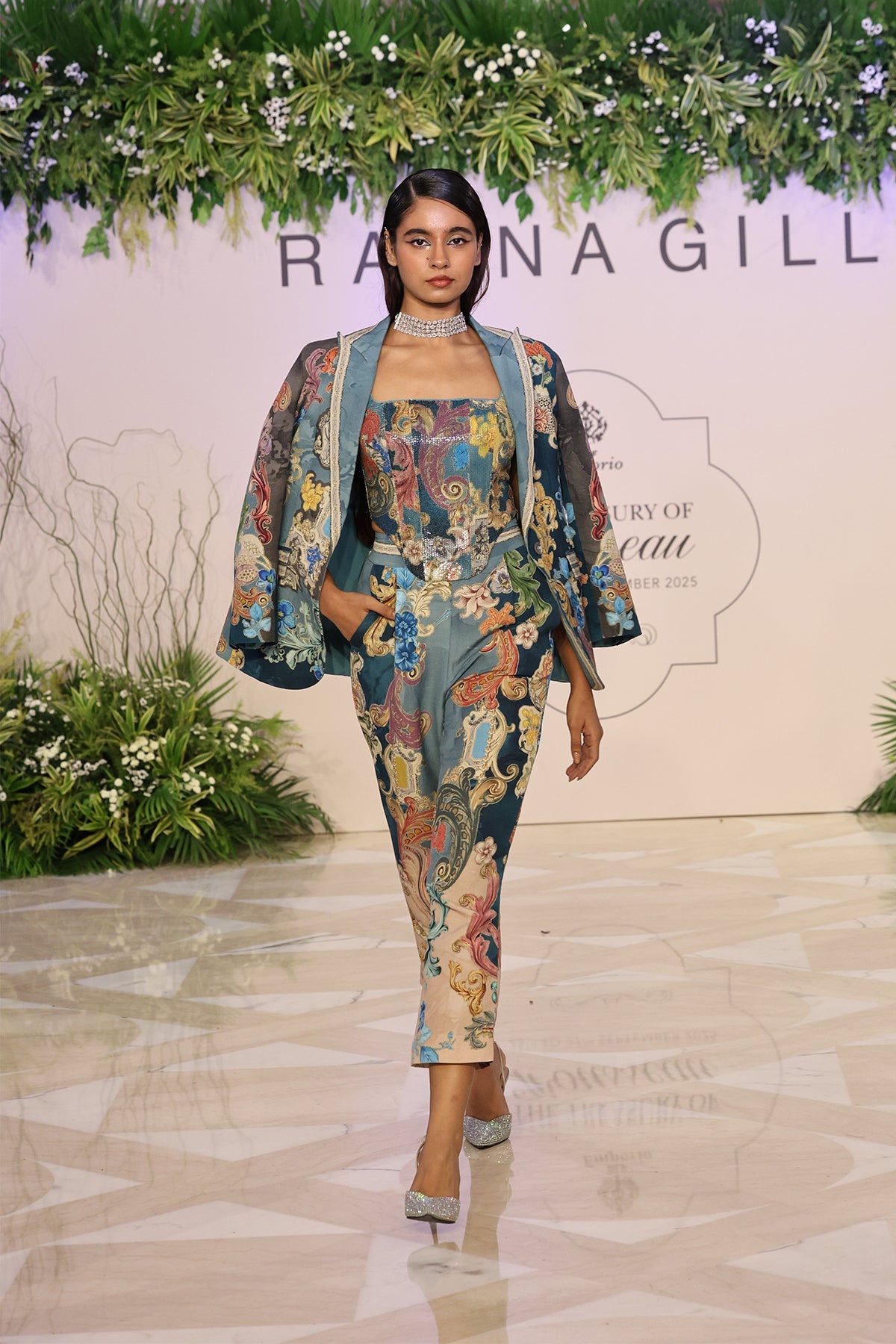 A floral outfit with a 'Rajna Gill' backdrop