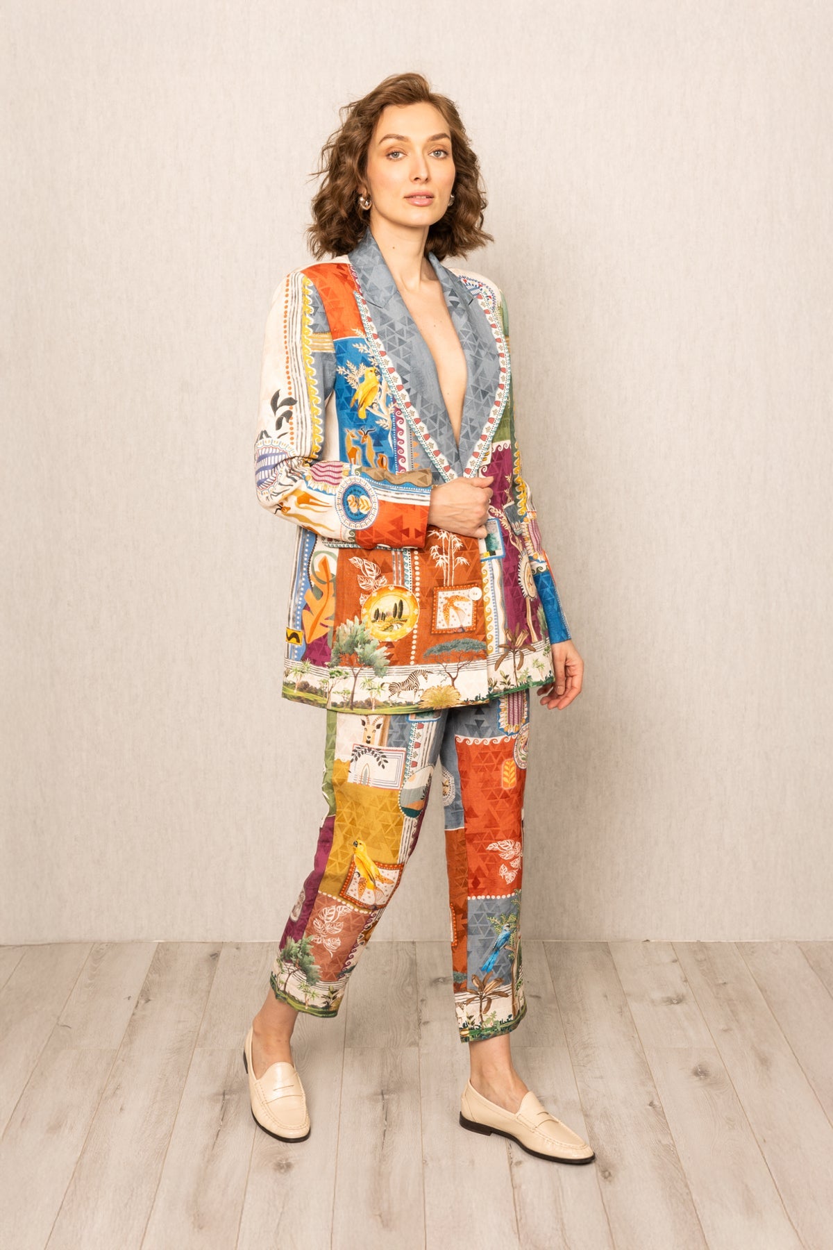 Woman wearing a colorful patchwork outfit against a plain background