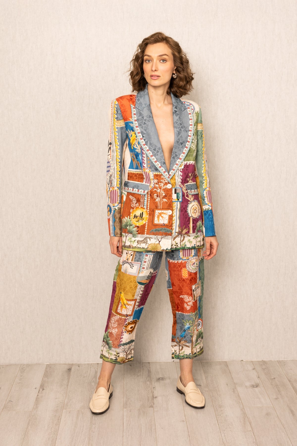 women wearing a colorful patchwork blazer against a plain background
