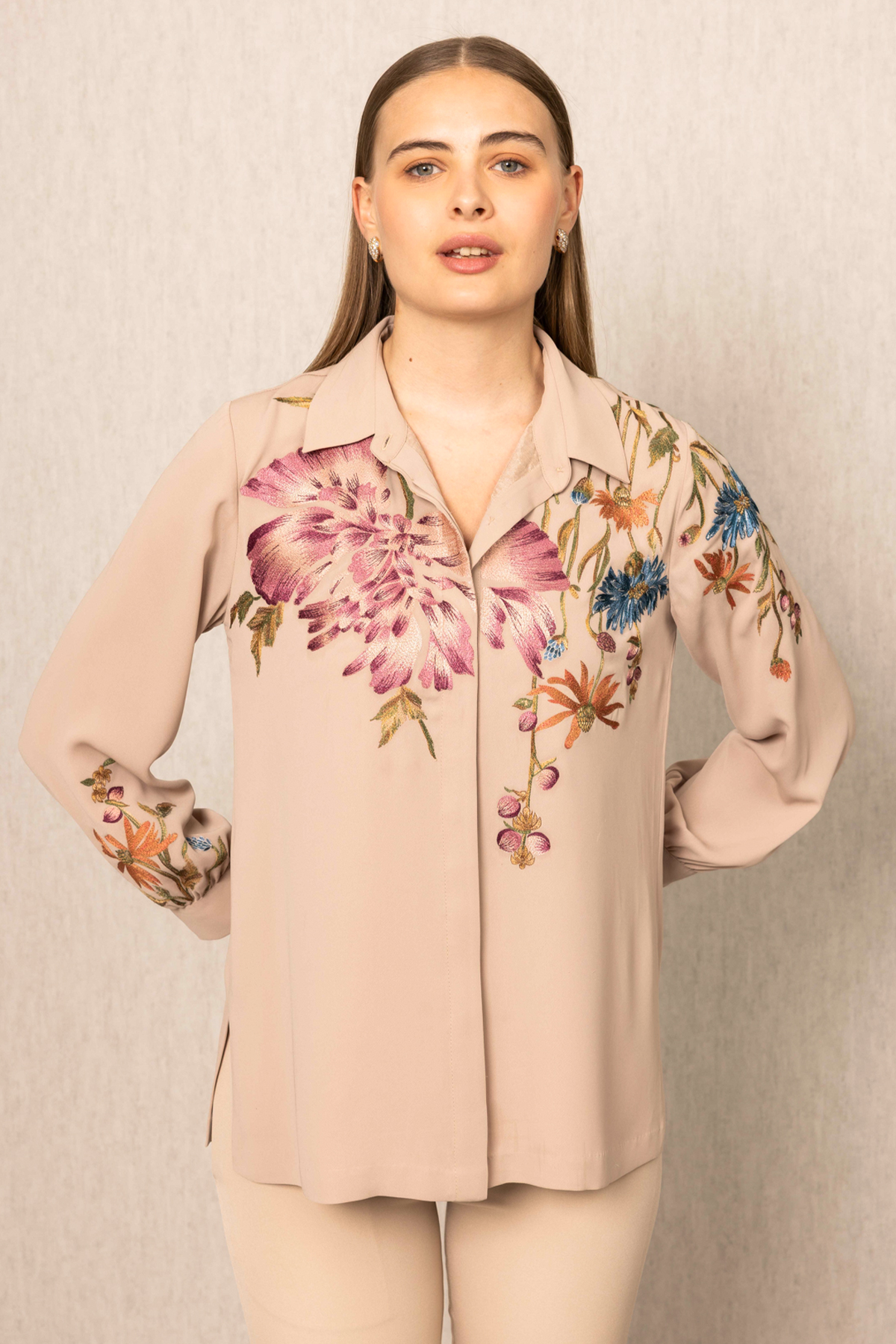 A beige blouse with floral embroidery