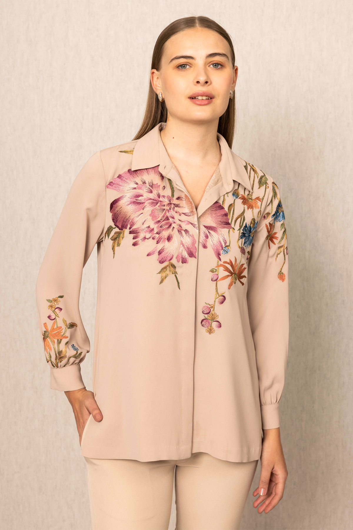 a beige blouse with floral embroidery