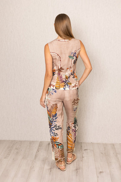 Back view of Ranna Gill Liora Rara Pants in beige linen-viscose fabric with vibrant tropical botanical prints in orange, green, blue, and black, featuring straight fit and elastic waistband.