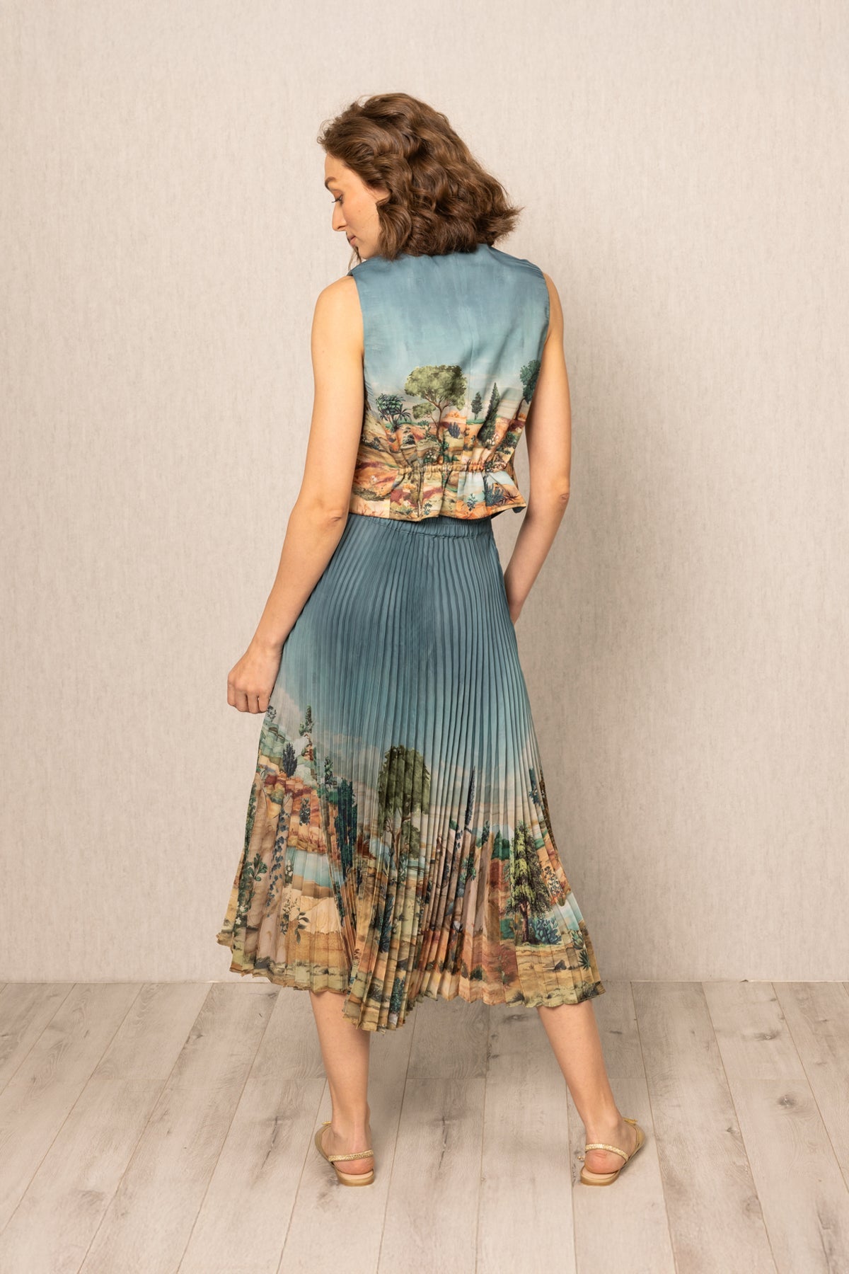 Ranna Gill Lyon Pleated Skirt in teal blue satin with Tuscany print and precision pleats.