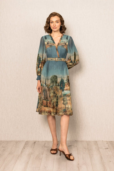 Woman wearing a patterned dress standing against a plain background