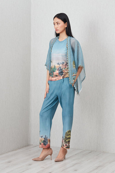 Woman wearing a blue outfit with floral patterns on a plain background