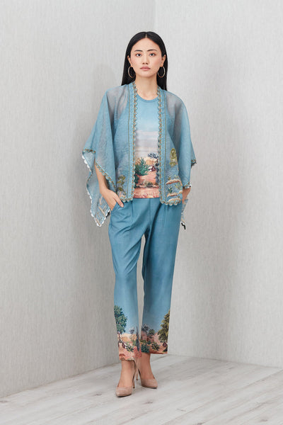 Woman wearing a blue outfit with floral patterns against a plain background