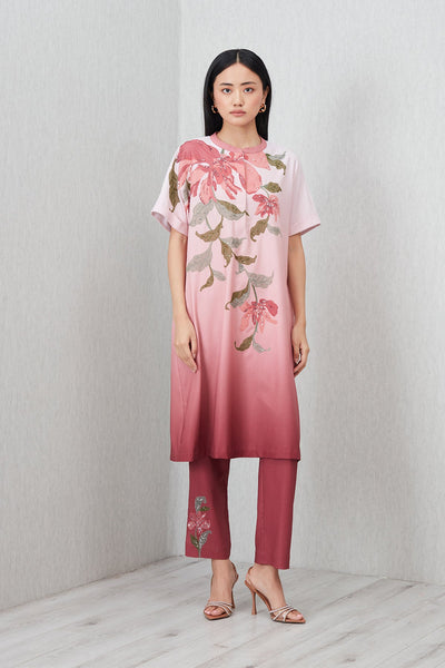 Woman wearing a pink floral dress and pants