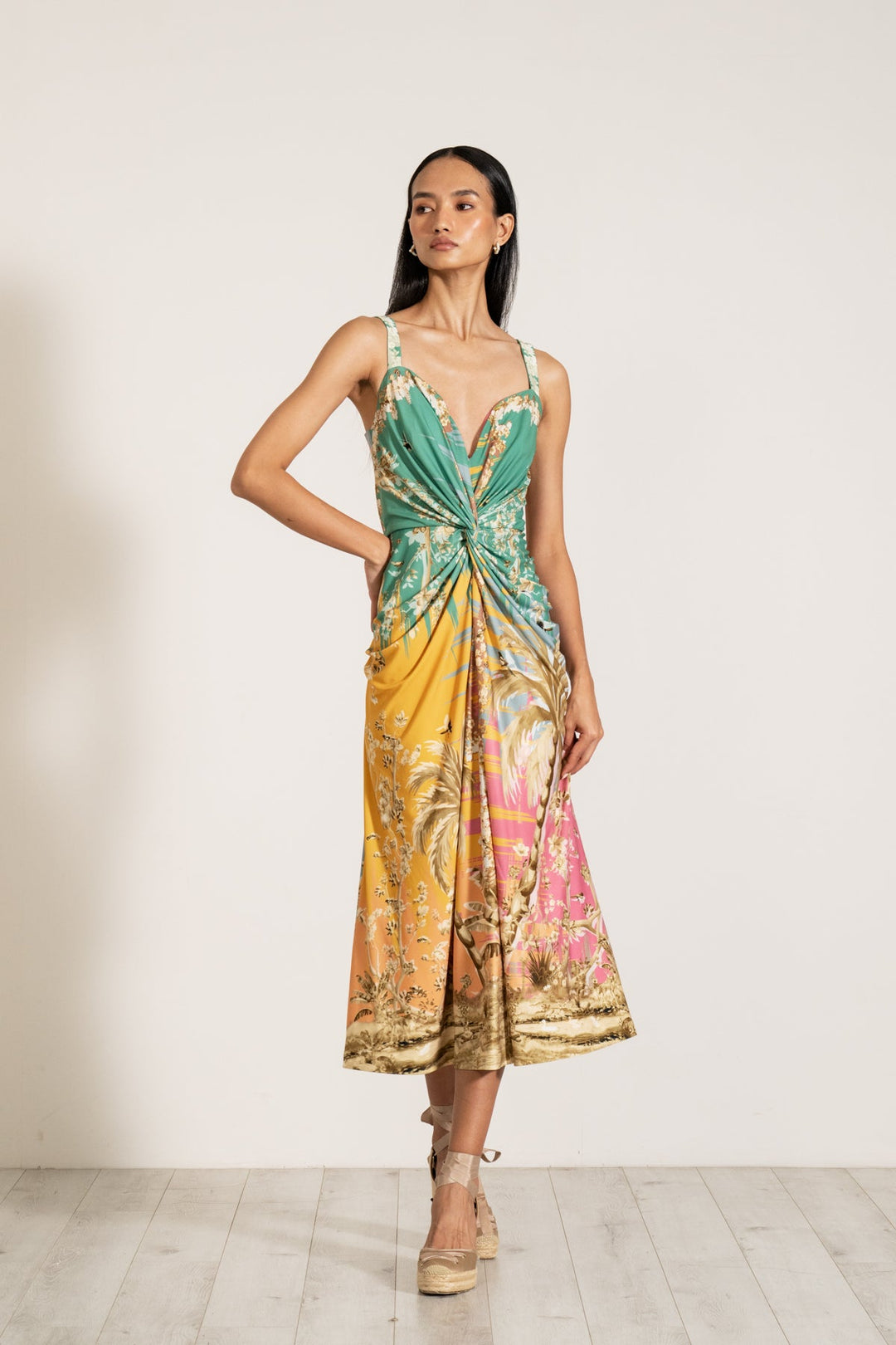Ranna Gill Celeste Twisted Midi Dress a sleeveless, twisted midi dress with a palm beach print.