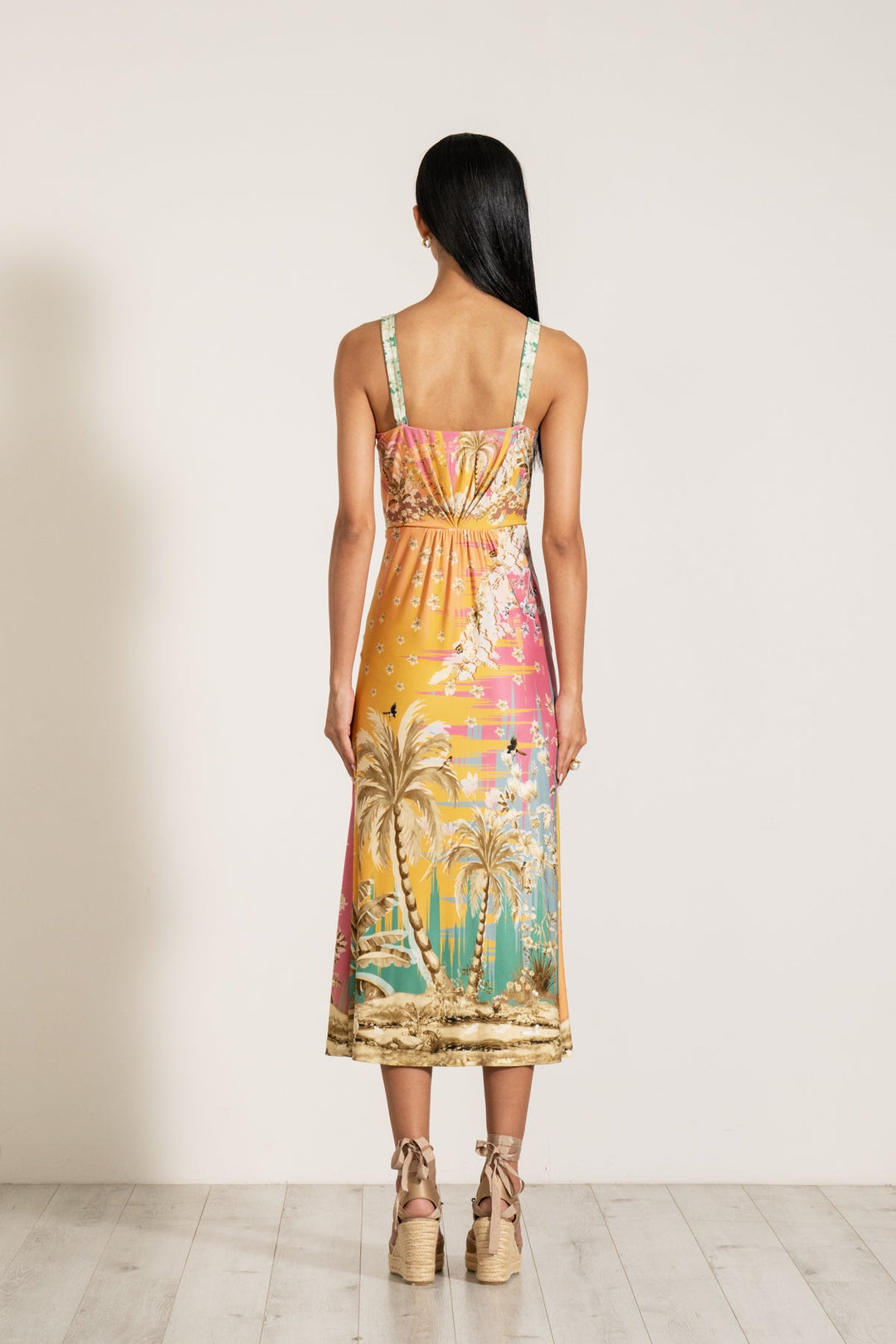 Ranna Gill Celeste Twisted Midi Dress a sleeveless, twisted midi dress with a palm beach print.