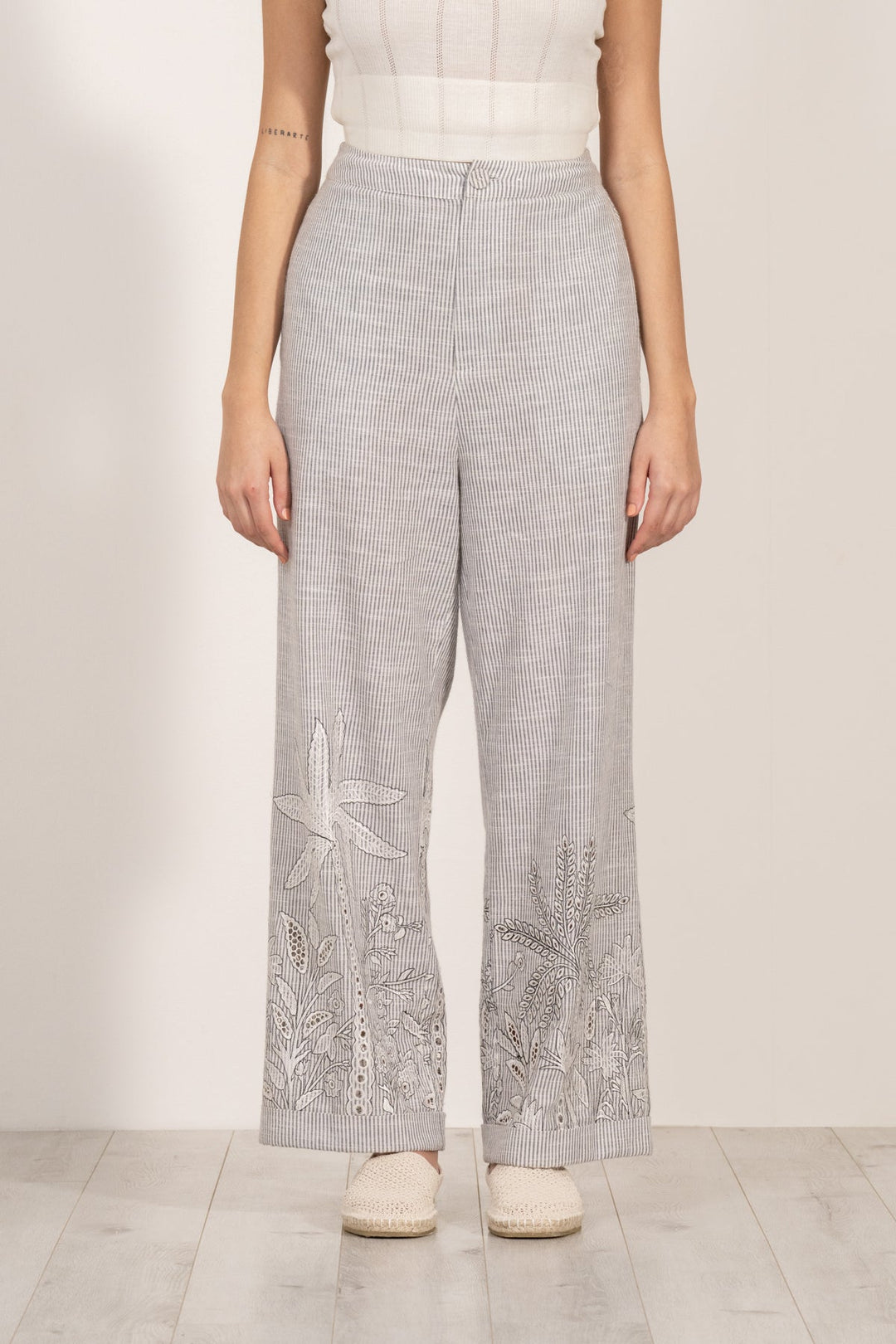 Verena high-waisted grey and white striped pants by ranna gill with aurora eyelet embroidery along the hemline.