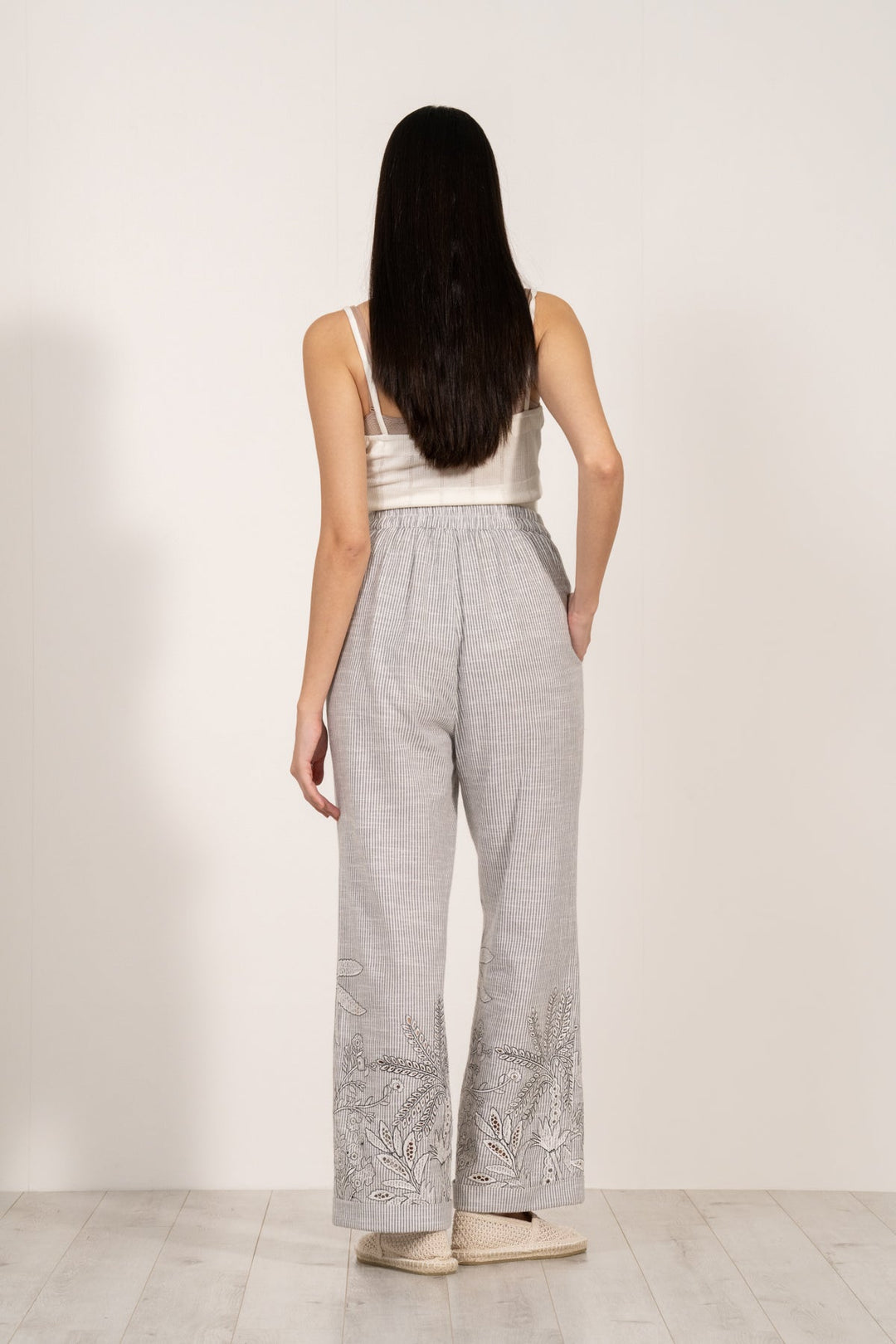 Verena high-waisted grey and white striped pants by ranna gill with aurora eyelet embroidery along the hemline.