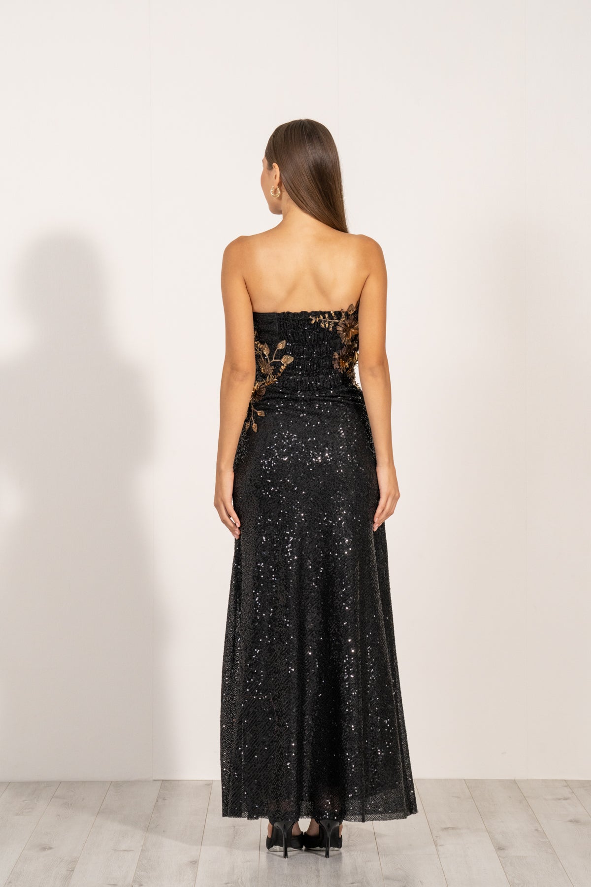 Aleysa Dress by Ranna Gill a black long dress with gold sequins and a thigh-high slit on the left side.